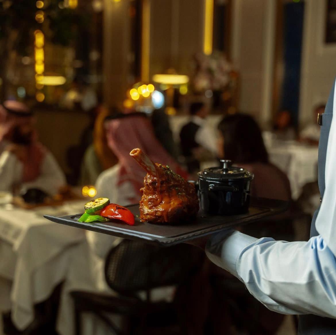 Jareed Hotel Riadh Exterior foto A waiter serving food